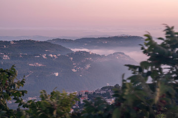 Beautiful colorful sunset over the mountain range and pine tree forest. Nature landscape. fogy sky with some orange reflections.