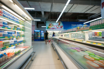 Supermarket blurred background with colorful shelves and unrecognizable customers