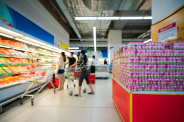 Supermarket blurred background with colorful shelves and unrecognizable customers