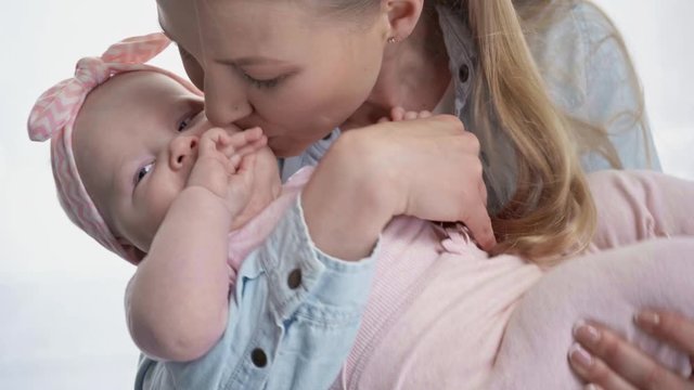 happy mother kissing cute baby at home