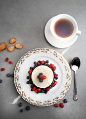 Delicious rice pudding with fresh berries and tea on a grey stone table