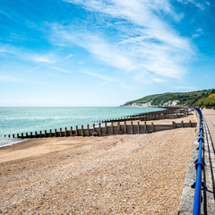 Obraz premium Eastbourne promenade and the South Downs, England. A bright, summer view west along the sea front towards the distant white cliffs and South Downs.