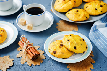 Chocolate chips pumpkin cookies with cups of coffee