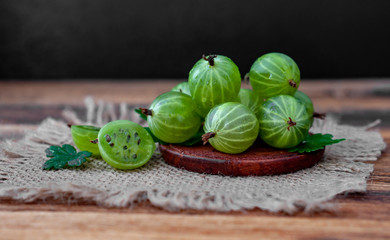 Green gooseberry berries on a wooden table