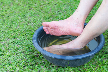 Close-up of senior woman foot spa with herbal