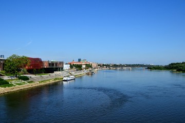 Obraz premium Summer cityscape, view from Swietokrzyski Bridge to Vistula river, the Vistula Boulevards promenade and Copernicus Science Centre. Warsaw, Poland