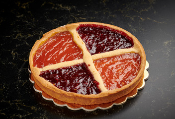 Bakery tart with marmalade on a golden board