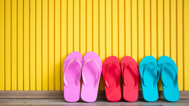 Summer sandal. Multicolored beach flipflops on yellow background. relaxation, vacation and holiday concept idea with copy space