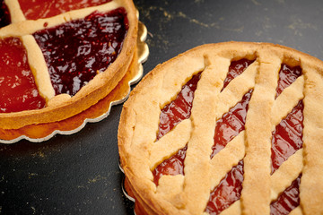 Two bakery tart with marmalade on golden board