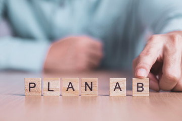 Businessman chooses a plan B word on wooden block , business success creative motivation concept