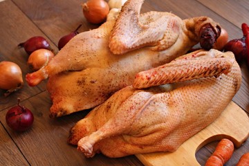Fresh goose carcass and vegetables prepared for cooking.