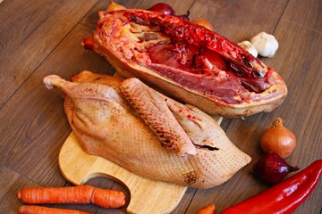 Fresh goose carcass and vegetables prepared for cooking.