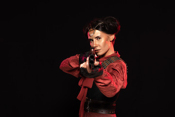 selective focus of steampunk woman aiming with gun to camera isolated on black
