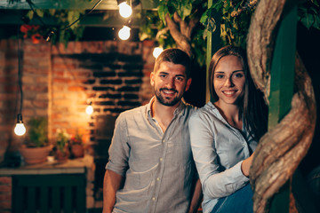 portrait of young happy couple, outdoor posing, moody night scene