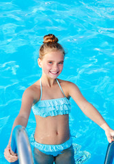 Cute smiling little girl child having fun in the swimming pool - 284827053