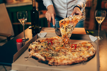 closeup of woman cutting pizza .