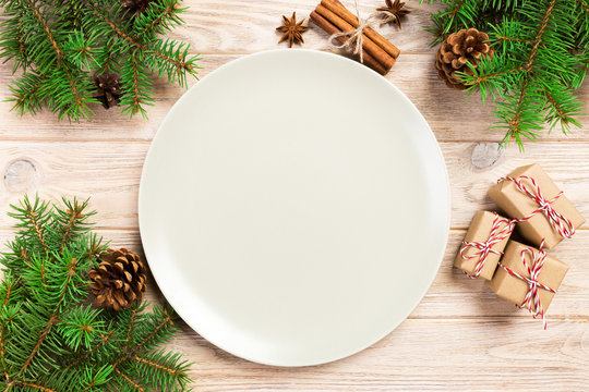 Empty white matte plate on wooden background with christmas decoration, Round dish. New Year concept