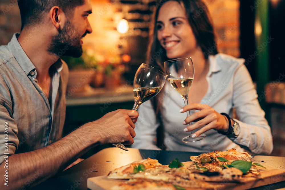 Wall mural young couple making toast with wine, at home in garden, evening scene