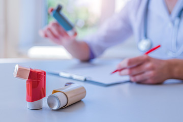 Doctor writes medical prescription for asthma inhaler to asthmatic patient during medical consultation and examination in hospital. Healthcare - obrazy, fototapety, plakaty