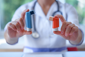 Asthma inhalers in doctor hands for asthmatic patient during medical consultation and examination. Healthcare - obrazy, fototapety, plakaty
