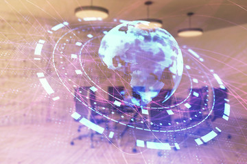 Double exposure of globe hologram on conference room background. Concept of international business