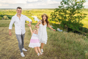 Family bonds. Happy young family of three smiling while spending free time outdoors. enjoying life together