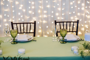 Beautiful composition with flowers on the tables and candles for guests at a wedding or a birthday party