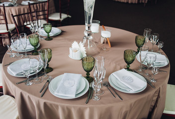 Beautiful composition with flowers on the tables and candles for guests at a wedding or a birthday party