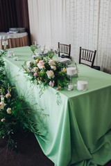 Beautiful composition with flowers on the tables and candles for guests at a wedding or a birthday party