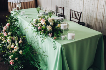 Beautiful composition with flowers on the tables and candles for guests at a wedding or a birthday party