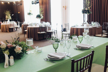Beautiful composition with flowers on the tables and candles for guests at a wedding or a birthday party