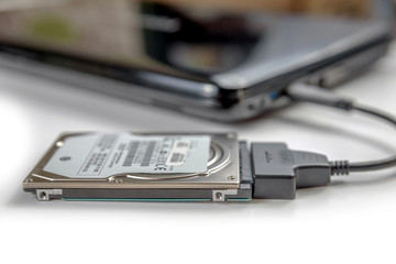 hdd 2.5 internal hard drive disk connected to laptop via sata usb cable closeup view