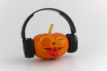 Halloween pumpkin with headphones for music.  Jack lantern from juicy pumpkin.