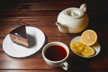chocolate cake slice with a white cup of tea
