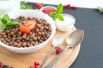Healthy breakfast ingredients. Healthy tasty breakfast chocolate balls with strawberries, raspberries, black currants and red currants.