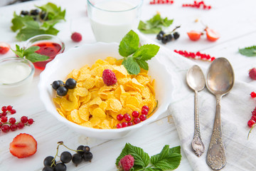 bowl of muesli and yogurt with fresh berries Healthy tasty breakfast cornflakes with strawberries, raspberries, black currants and red currants.