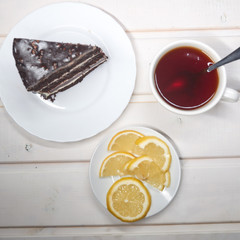 chocolate cake slice with a white cup of tea