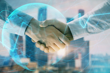 Obraz na płótnie Canvas Double exposure of financial chart and world map on cityscape background with two businessmen handshake. Concept of international investment