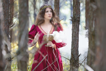 Woman in a red dress casting a spell with smoke