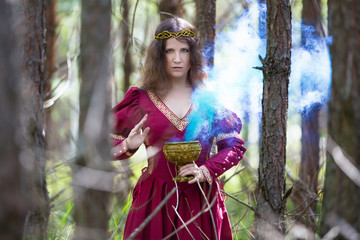 Woman in a red dress casting a spell with smoke