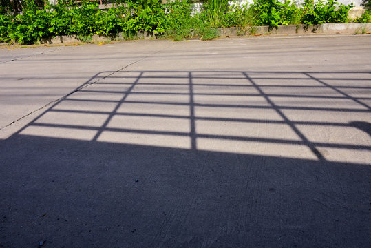 The shadow of car grille apper on the street.