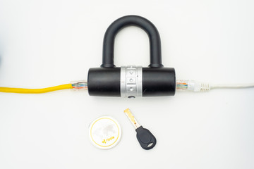 Two computer network cables going through a lock with a key and a crypto currency coin, depicting digital security, cybersecurity or internet security
