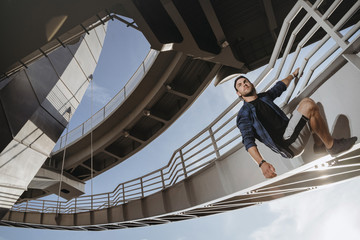 Portrait of parkour athlete climbing on the bridge.