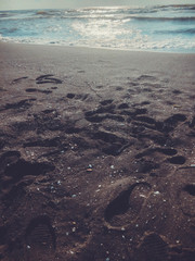 View of the sea during sunset. Glitter waves on a sandy beach. Summer sunny day, water background