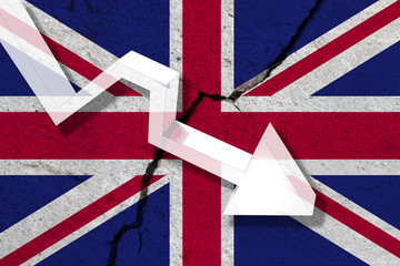 United Kingdom on the cracked wall with arrow falling down. Concept of decrease in the UK.