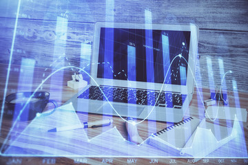 Financial graph colorful drawing and table with computer on background. Multi exposure. Concept of international markets.