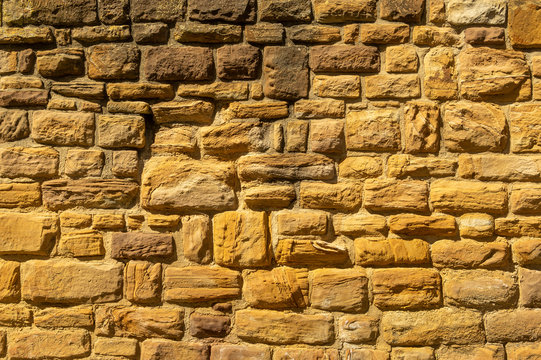 Sandsteinmauer mit Sandsteinen mit reliefartigen, k&uuml;nstlerischen Mustern, Schraffuren und Formen
