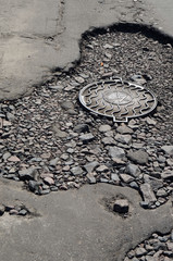 Poor condition of the road surface. Summer season. Hole in the asphalt, risk of movement by car, bad asphalt, dangerous road, potholes in asphalt.  Kiev,Ukraine