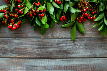Summer pattern with green plants and red berries on wooden background top view mockup