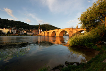 Fototapeta na wymiar Neckarufer in Heidelberg mit Blick auf die Alte Brücke und die Altstadt in der Morgensonne
